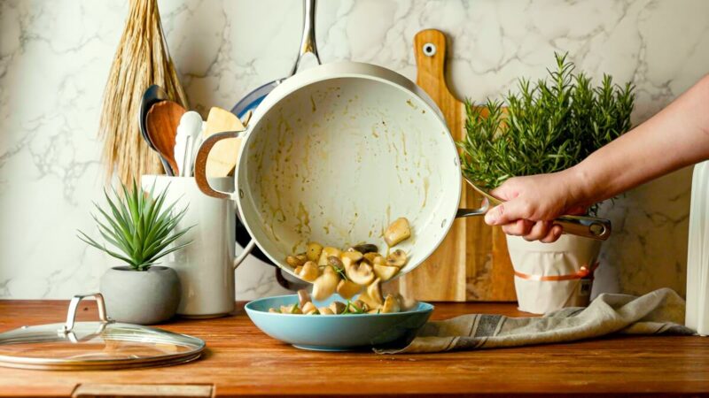 Food Being Poured Out of Ceramic Pan. Concept for Ceramic Vs. Stainless Steel Comparison