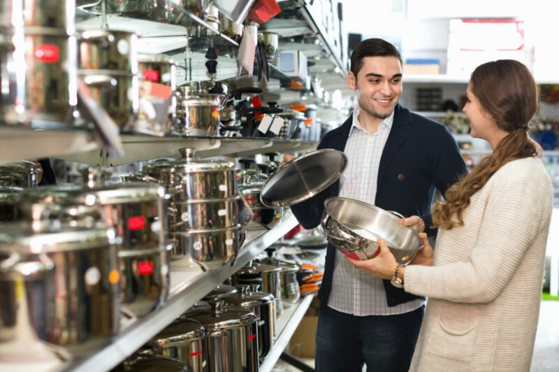 Couple Buying Cookware. Concept for Price Comparison Between Stainless Steel and Ceramic Cookware